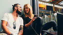 hip young couple with smartphone and laptop