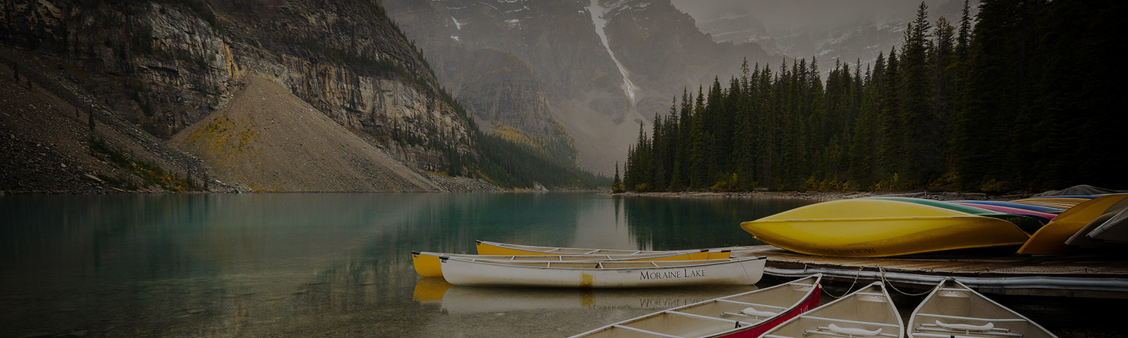 canoes on a lake between mountains