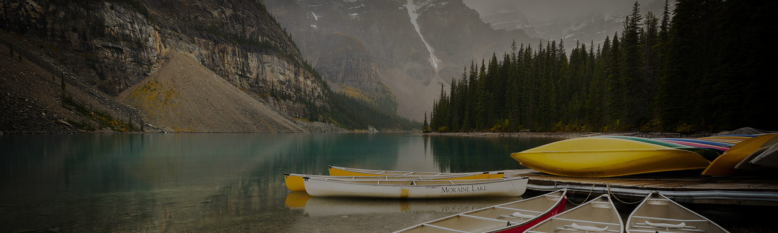 canoes on a lake between mountains 