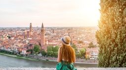 Woman enjoying beautiful sunset view on Verona city in Italy