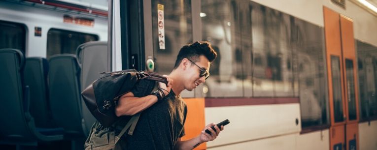 Allianz - young man waiting for a train at the train station
