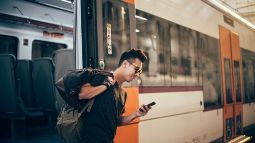 young man waiting for a train at the train station