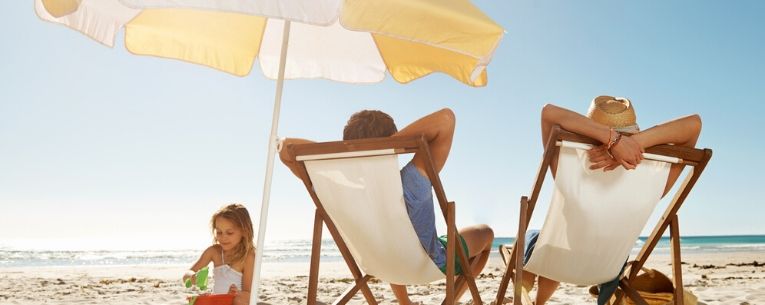 Allianz - couple relaxing on the beach while daughter plays in the sand