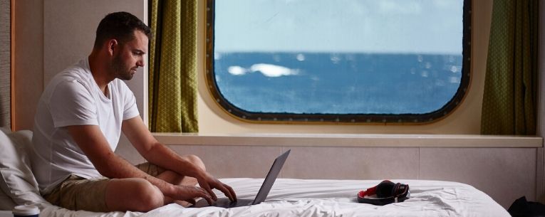 Allianz - man using laptop on cruise ship