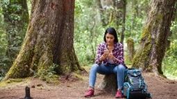 woman with smartphone in forest