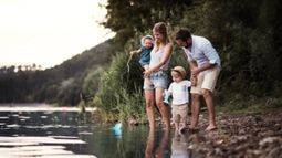 family with two toddlers fishing at lake