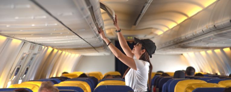 Allianz - woman stowing away carryon bag on airplane