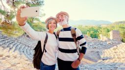 two senior travelers taking a selfie together