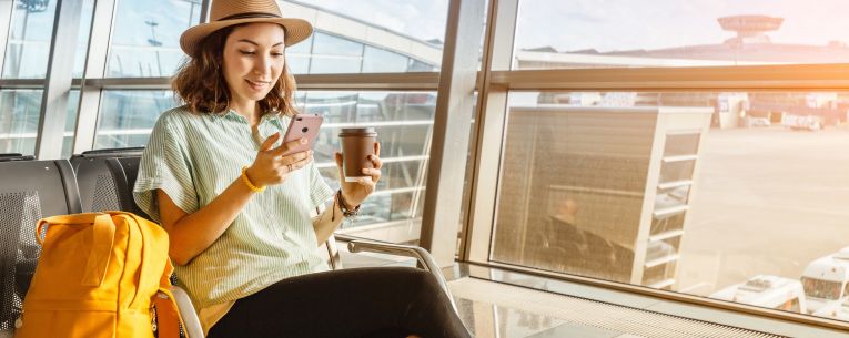 Allianz - woman using phone while waiting in airport
