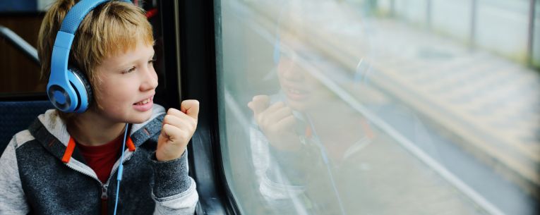 Allianz - child with headphones on train